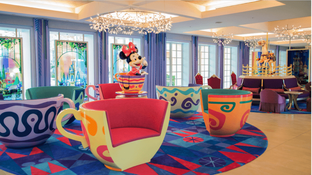 東京ディズニーセレブレーションホテル（ウィッシュ）のロビー。ティーカップに乗ったミニーマウスの大きなオブジェや、アリスのティーパーティーをモチーフにしたカラフルなソファが置かれ、パークの余韻を楽しめる空間。