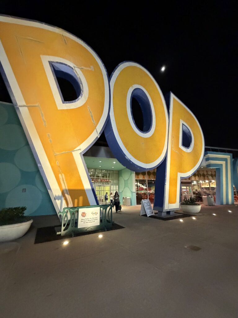夜のポップセンチュリーリゾート正面エントランス。巨大なPOPのロゴオブジェが輝いている