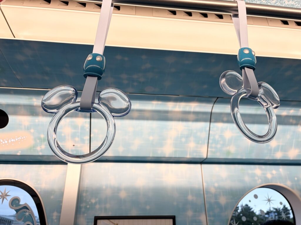 Close-up of clear Mickey-shaped handrail on Disney Resort Line — looks like a water bubble