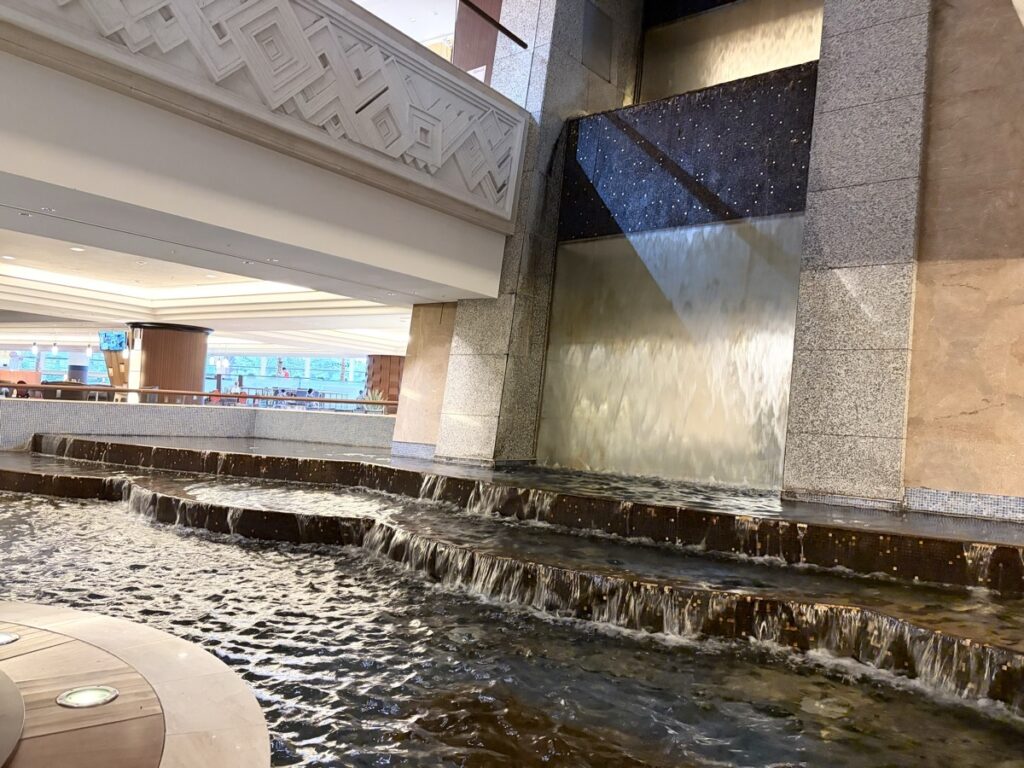 Sheraton Grande Tokyo Bay entrance waterfall cascading down stone wall, Disney hotel lobby feature