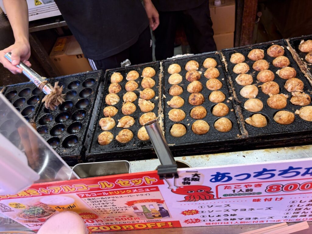 Atchi-chi Honpo staff cooking takoyaki fresh in Dotonbori — made right in front of you