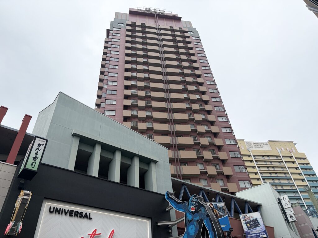 Hotel Kintetsu Universal City Osaka — red building visible from the station, entrance next to McDonald's