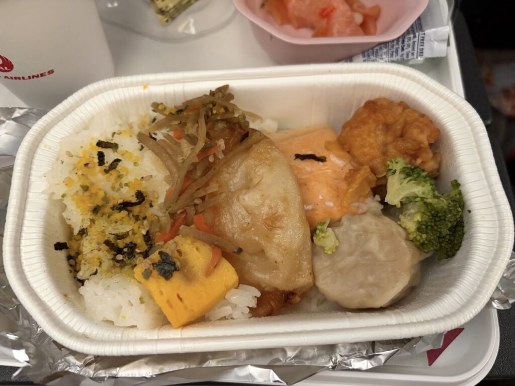 JAL機内食のサーモン塩焼き弁当。ふりかけご飯に玉子焼き、シュウマイ、唐揚げ、ブロッコリー