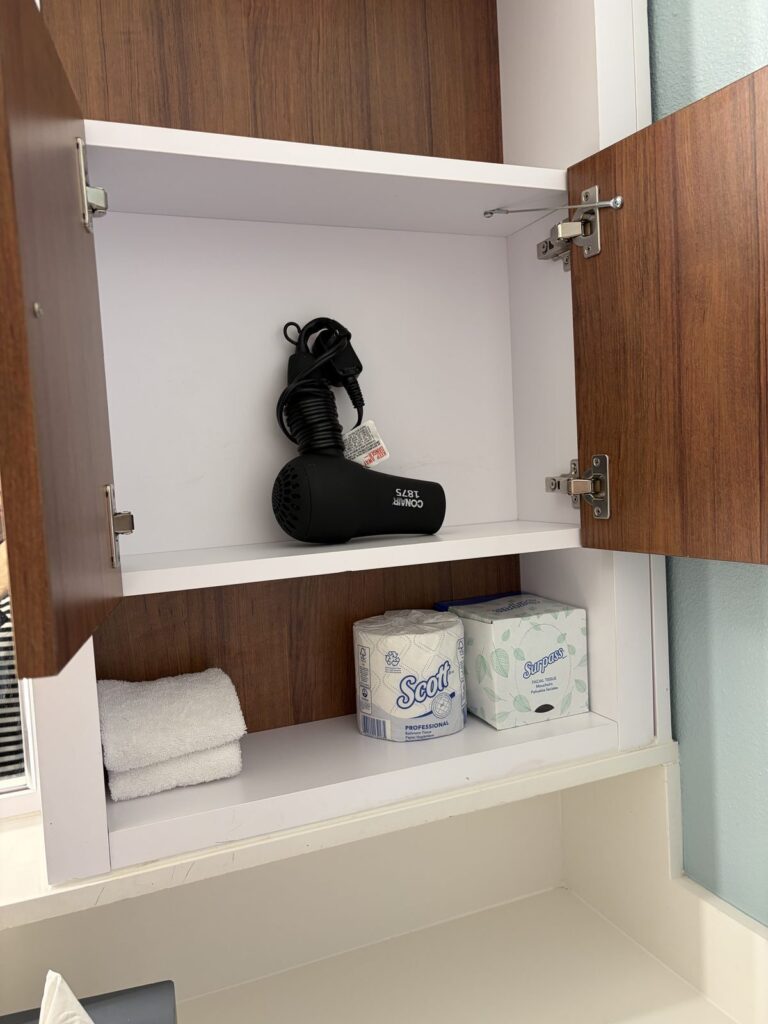 ポップセンチュリー客室洗面所の収納。ドライヤーと予備のトイレットペーパー・ティッシュ