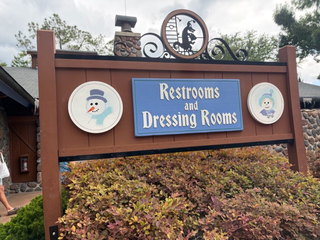 ブリザードビーチの「Restrooms and Dressing Rooms」と書かれた木製の案内看板。トイレと更衣室が同じ建物にあることが分かる
