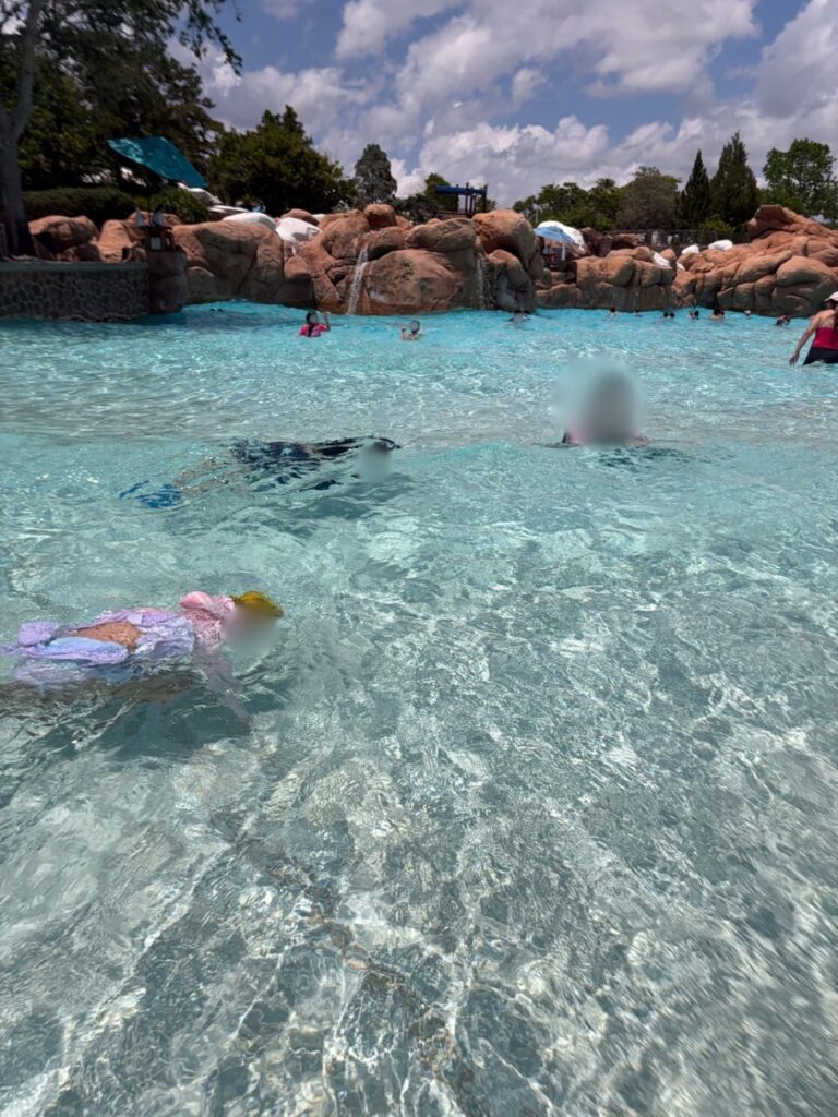 ブリザードビーチの波のプールの浅瀬で、うつ伏せに浮かんで波に揺られている子ども