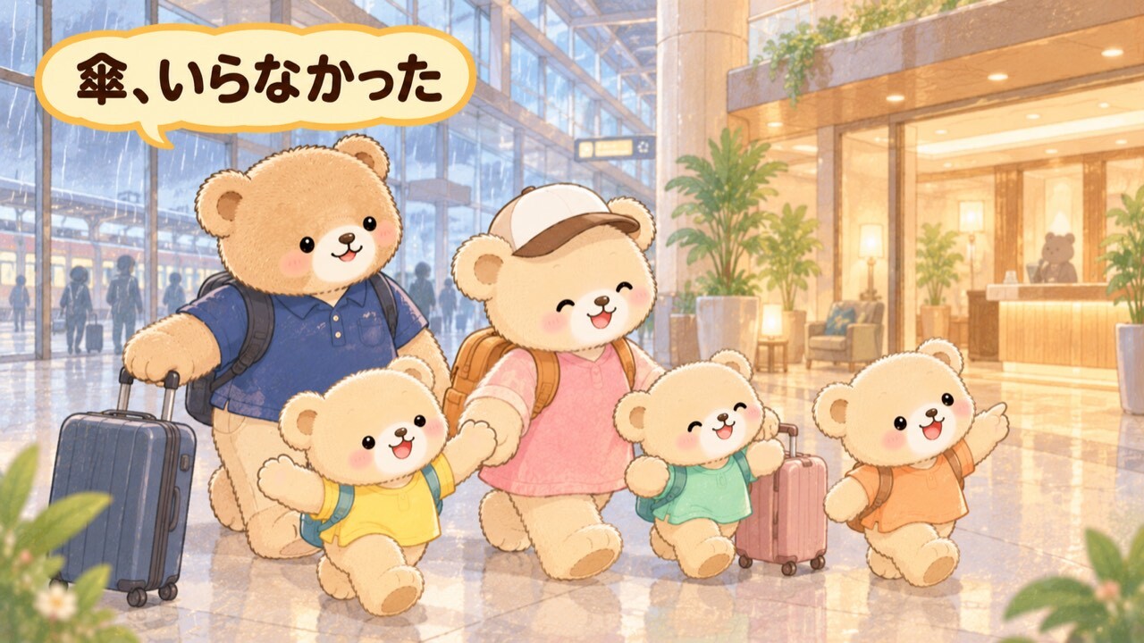 雨の日の駅構内を歩く5人家族のくまちゃん。ガラスの外は雨だが、誰も傘をさしておらず全員乾いている。スーツケースを引くパパぐまと、白いキャップのママぐま、子ぐま3匹(黄色・ミントグリーン・オレンジ)が、正面に見える明るいホテルの入口へ向かっている。京都駅直結のホテルなら雨でも濡れずにチェックインできることを表したイラスト。「傘、いらなかった」の吹き出しつき。