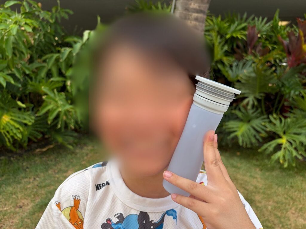 子どもが白い氷嚢を頬に当てて涼んでいるところ