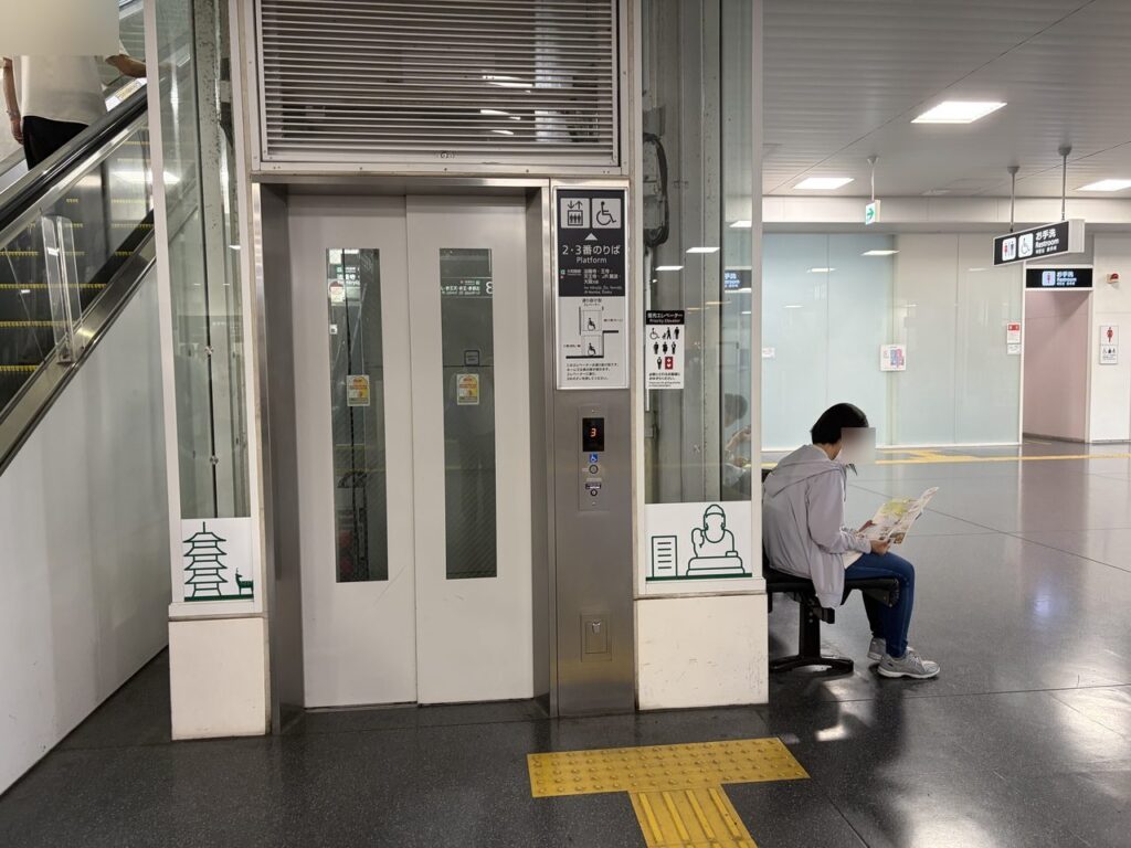 JR奈良駅の2・3番のりばへ上がるエレベーターの外観。車椅子とベビーカーのマークが付いている