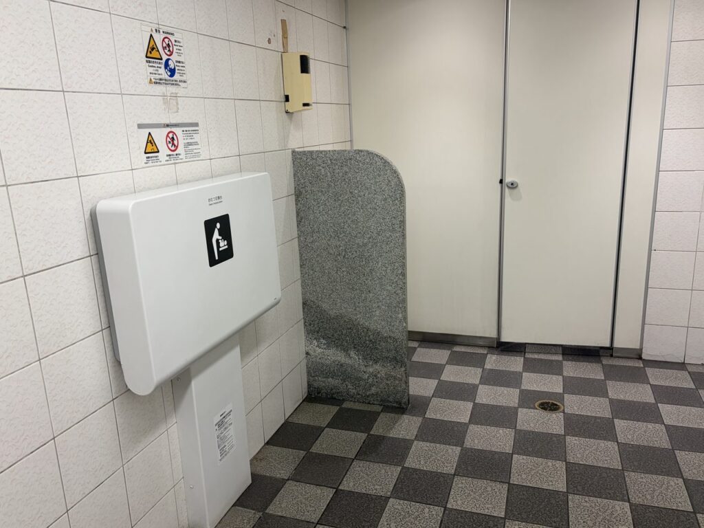 近鉄奈良駅の女子トイレ内に設置された壁付けのおむつ替え台。白いタイル張りの広いスペース