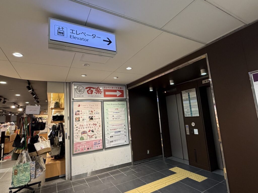 近鉄奈良駅の2回目のエレベーターの入口。上に「エレベーター Elevator →」の青い案内板が出ている