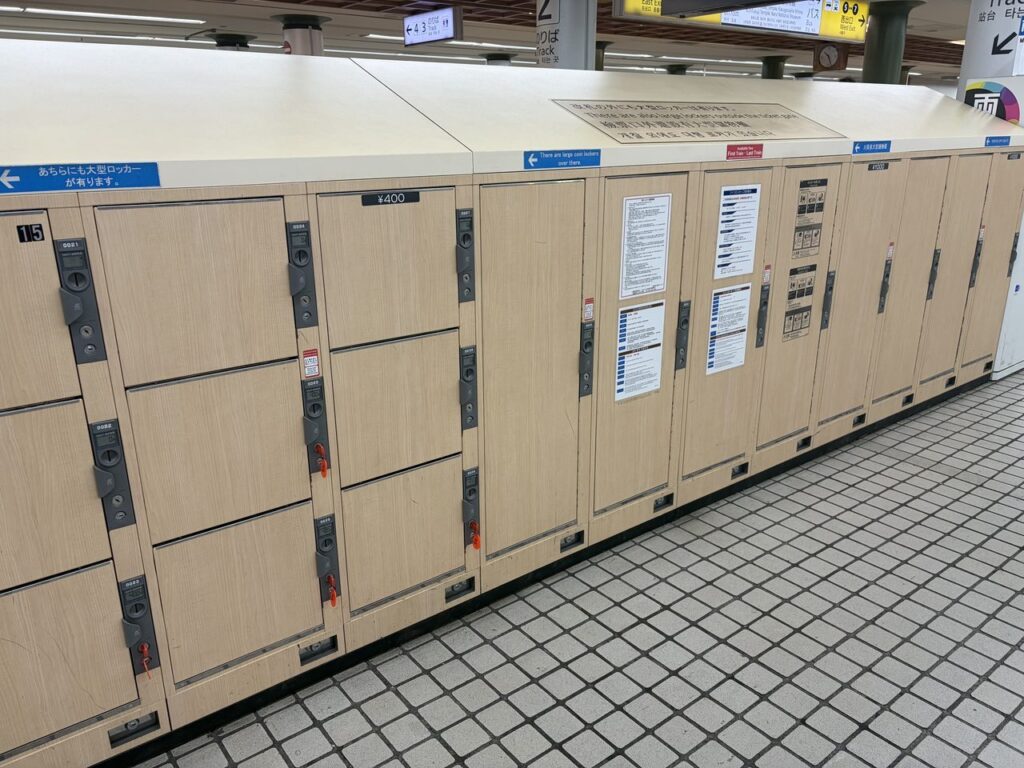 近鉄奈良駅の改札前に並ぶ木目調のコインロッカー。400円の表示と「あちらにも大型ロッカーが有ります」の青い案内が見える