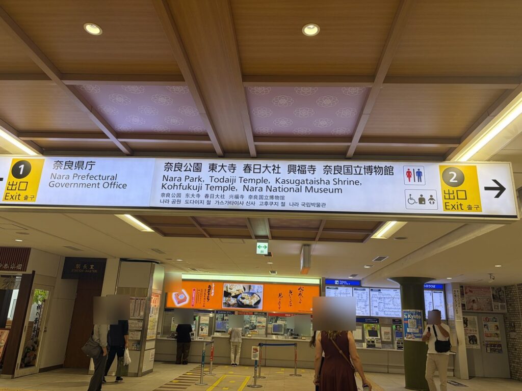 近鉄奈良駅の案内板を別角度から見たところ。出口1(奈良県庁)と出口2の矢印、奈良公園・東大寺などの行き先が書かれている