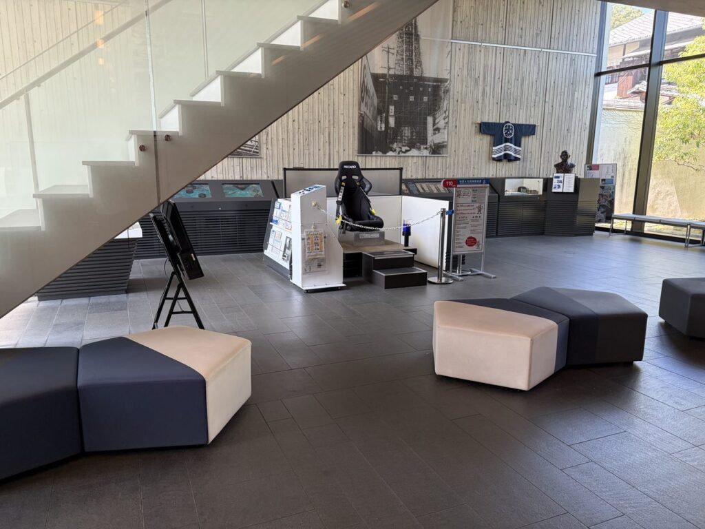 奥村記念館の館内。ソファ席と地震体験装置が置かれた広いロビー