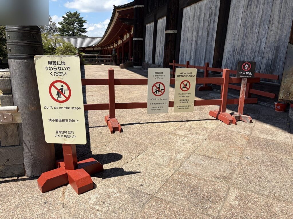 東大寺の階段前に立てられた案内板。「階段にはすわらないでください」「ベビーカーを置かないでください」「立入禁止」と多言語で書かれている