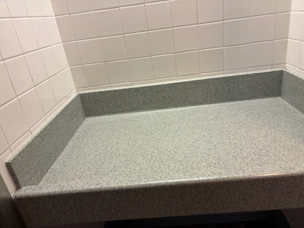 パーク内トイレに備え付けられた、三方が立ち上がった横長のオムツ替え台。