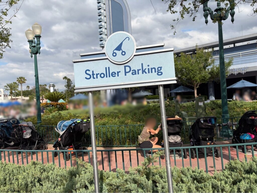 ハリウッドスタジオの「Stroller Parking」の案内板と、柵沿いに並べて置かれたベビーカーの列。