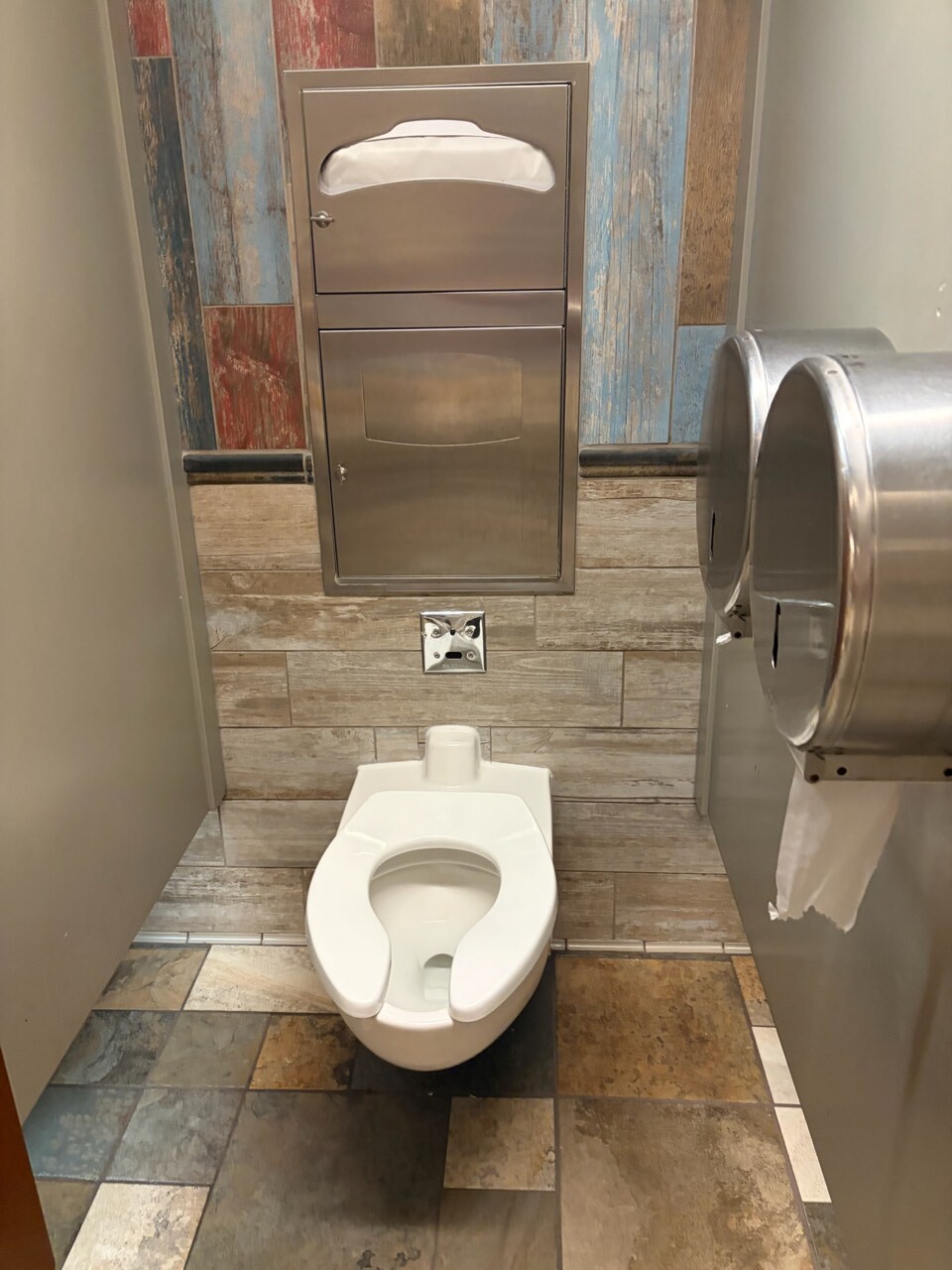 マジックキングダムのトイレの個室。便座と使い捨て便座シートのディスペンサー